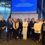 Grupa osób stojąca przed ekranem z prezentacją podczas konferencji o diagnozie młodzieży 2026