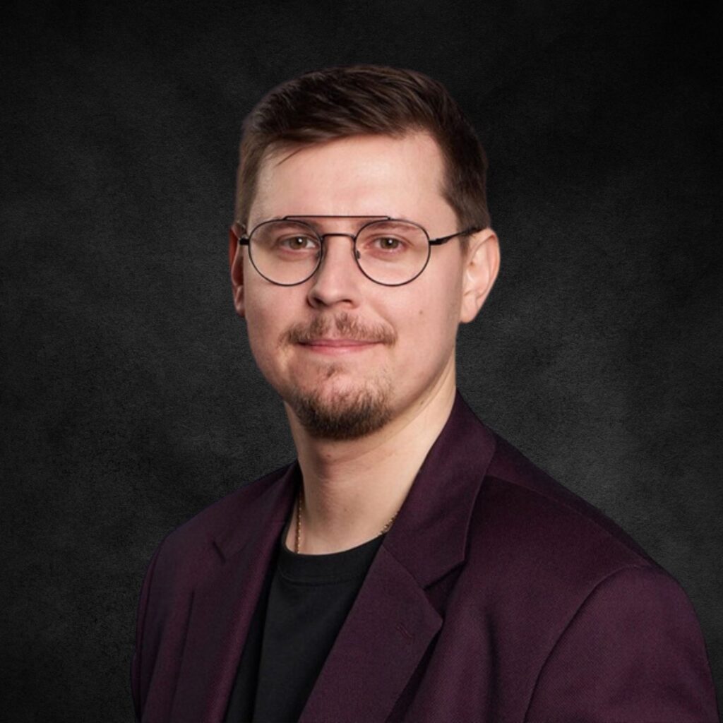 Portret mężczyzny w okularach i bordowej marynarce na ciemnym tle