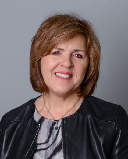 Portret kobiety w czarnej skórzanej kurtce na jasnoszarym tle