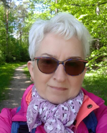 Portret kobiety w okularach przeciwsłonecznych na leśnej ścieżce