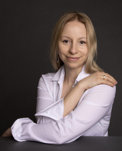 Portret kobiety w jasnej koszuli na ciemnym tle