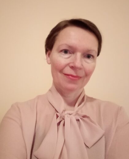 Portret kobiety w jasnoróżowej bluzce z wiązaniem pod szyją na jasnym tle