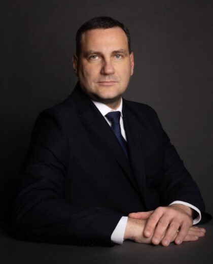 Portret mężczyzny w ciemnym garniturze i krawacie na ciemnym tle