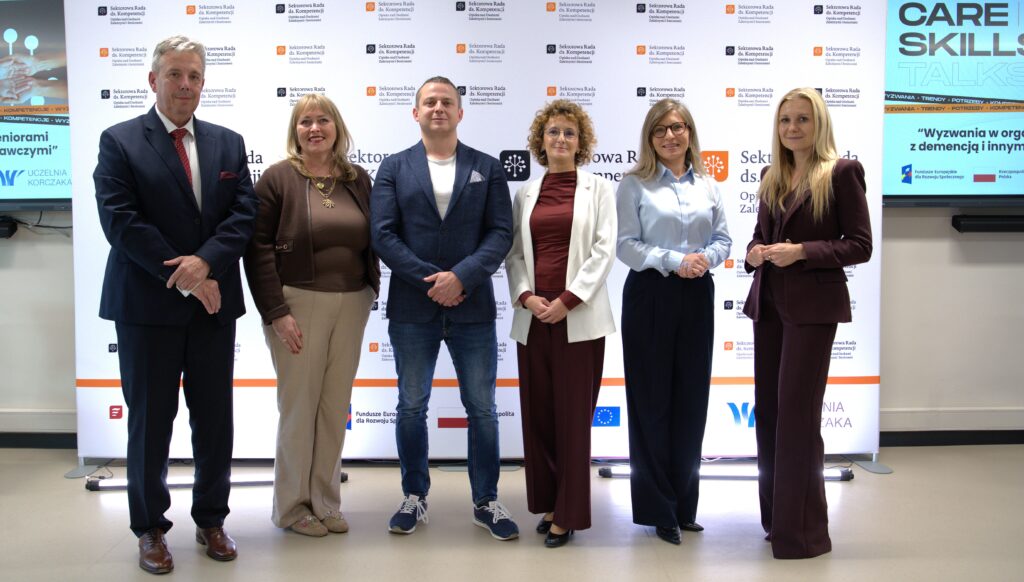 Prowadzący i eksperci CARESKILLS TALKS 3 pozują do wspólnego zdjęcia przed ścianką Sektorowej Rady ds. Kompetencji.