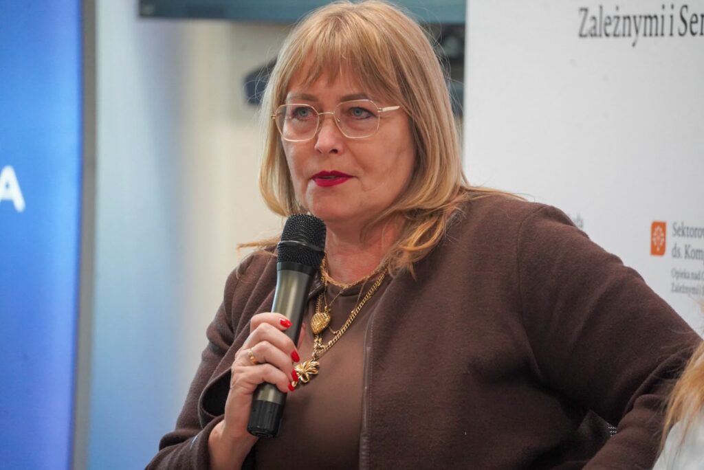 Ekspertka w brązowym stroju zabiera głos podczas panelu dyskusyjnego
