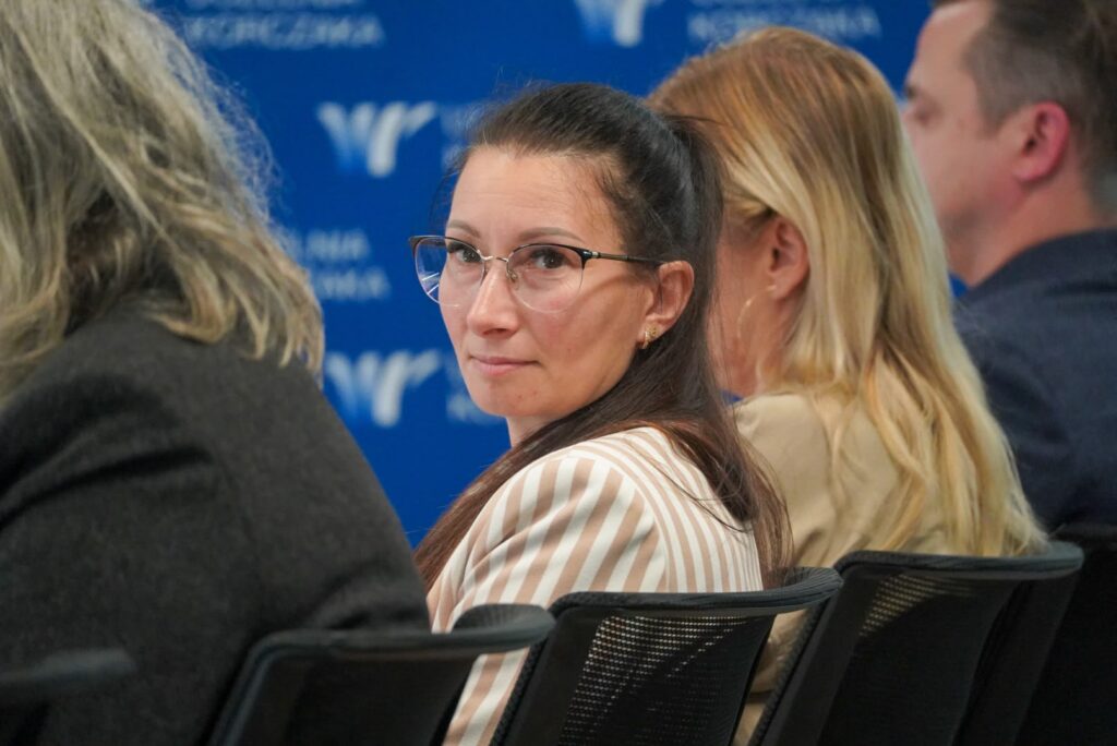 Uczestnicy wydarzenia słuchają dyskusji w sali Uczelni Korczaka