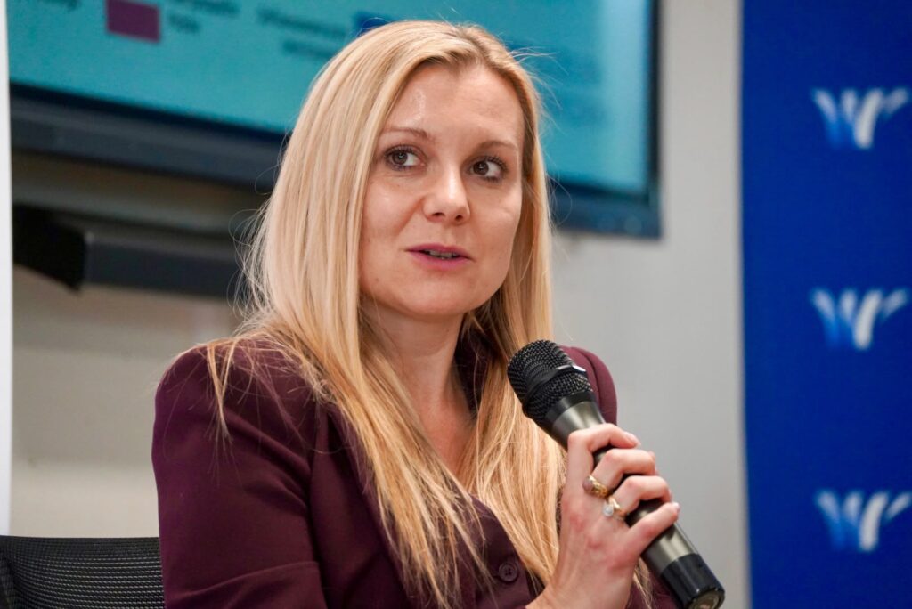 Prezes Sihtly Edyta Kocyk w bordowym garniturze odpowiada na pytania podczas debaty