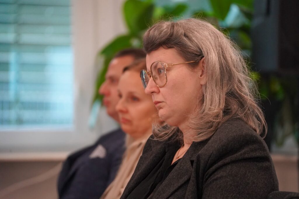 Uczestniczka spotkania słucha debaty w sali Uczelni Korczaka